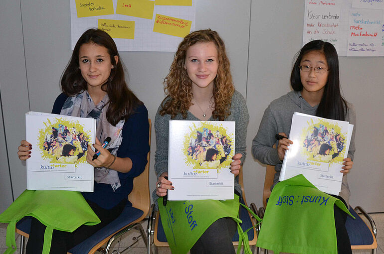 Junge Kulturstarter mit Ordnern in der Hand